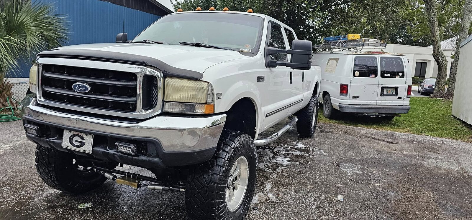 Front of a white lifted Ford F-350, wheels and tires shined